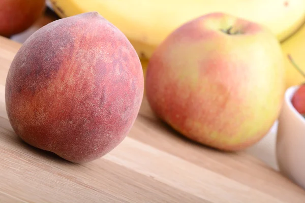 Frukt på fastigheten tabell, persika, äpple, bananer, mat koncept — Stockfoto