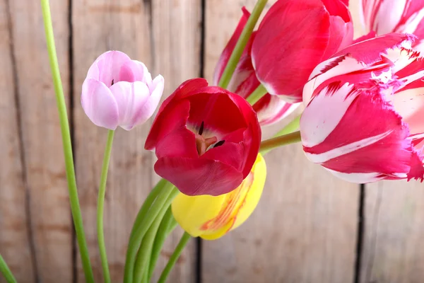 Ramo de tulipanes rojos sobre un fondo de madera, flores de cerca —  Fotos de Stock