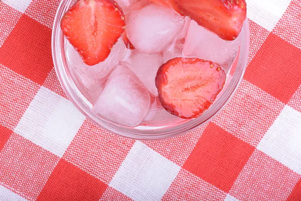 Шматочок червоної полуниці на скляній тарілці на фоні вечірки — стокове фото