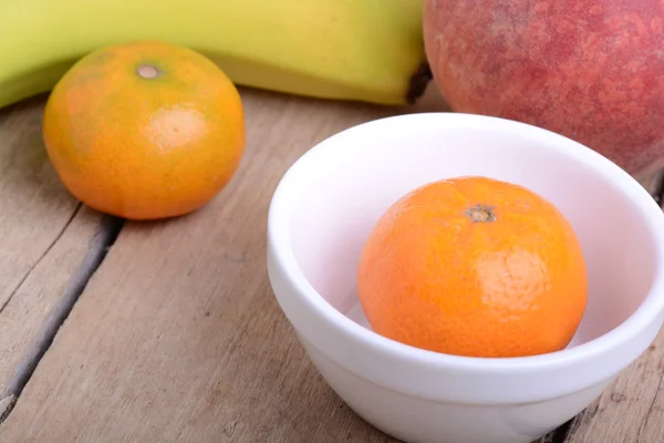 Banany jabłko mandarynka brzoskwinia truskawka na drewniane tła jako pojęcie zdrowia żywności — Zdjęcie stockowe