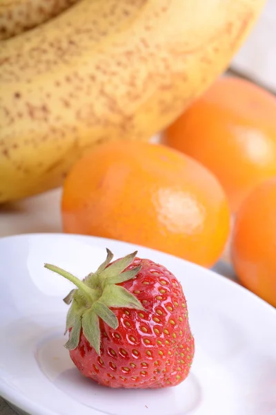 Świeże owoce kolorowy kompozycja mandarynki, truskawki, brzoskwinia, banany i pomarańczowy — Zdjęcie stockowe