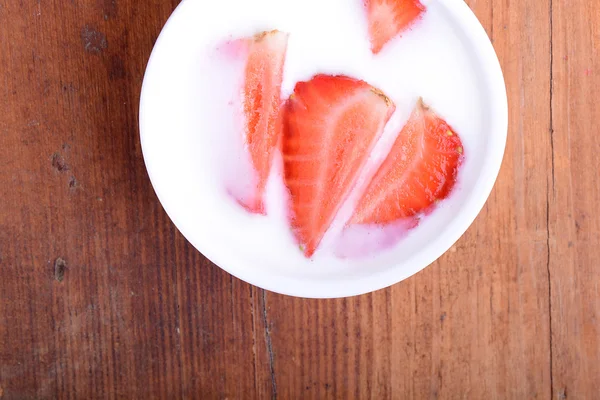 Rebanada de pastel con fresa en plato blanco, bebida de leche, fondo de madera. Vista superior —  Fotos de Stock