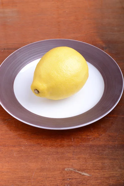 Fresh lemon on grey plate — Stock Photo, Image