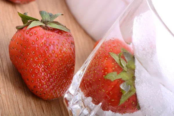 Erdbeere auf Holzteller und Erdbeere eingefroren mit Eis im Becher — Stockfoto