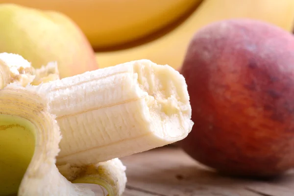 Frutas en la mesa, manzana, plátanos, melocotón de cerca, concepto de alimentos saludables — Foto de Stock