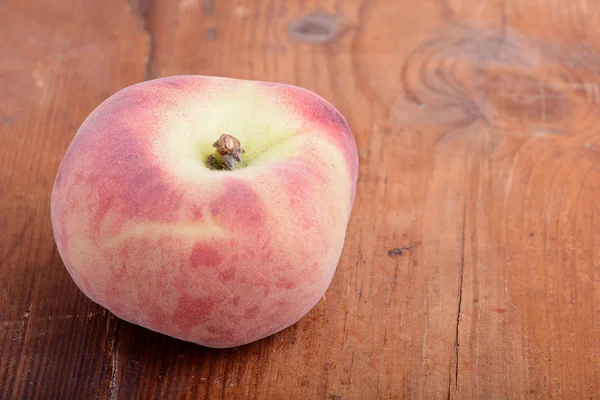 Peach på trä bakgrund — Stockfoto