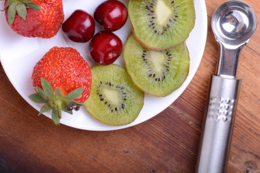 meyve kiraz, çilek, kivi ahşap plaka üzerinde