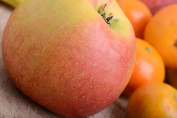 Bananer apple mandarin persika jordgubbar på trä bakgrund som hälsokost begrepp — Stockfoto