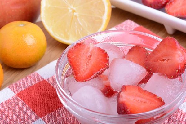 Une tranche de fraise rouge sur une assiette en verre avec du citron et de la mandarine dans le fond du thème de la fête — Photo