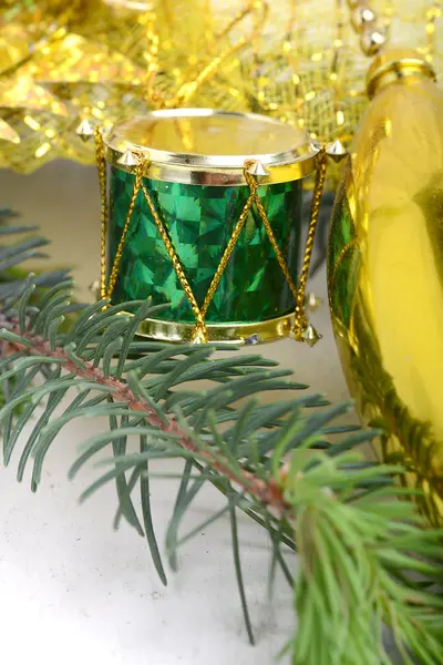 Fundo de Natal com tambores, ramo de árvore de véspera verde, decoração de ano novo dourado — Fotografia de Stock