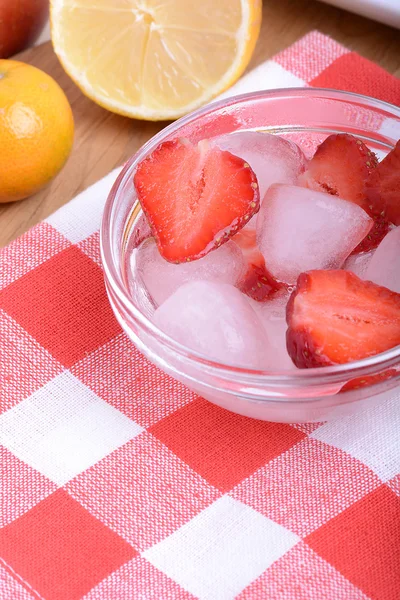 Eine Scheibe rote Erdbeere auf Glasplatte mit Zitrone und Mandarine im Hintergrund des Party-Themas — Stockfoto