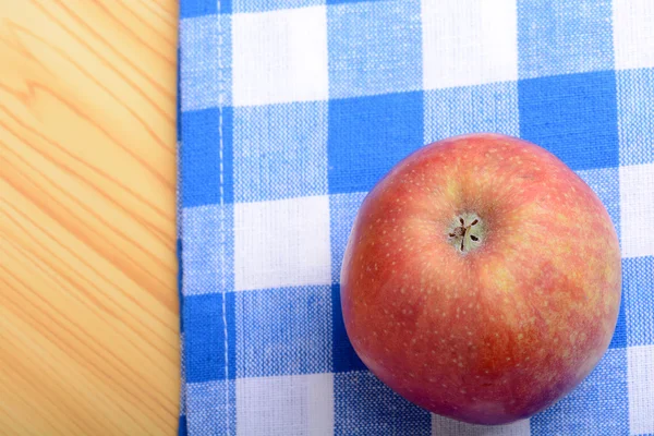 Rött äpple ovanifrån på blå materiella bakgrund — Stockfoto