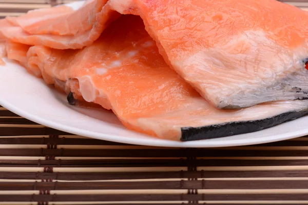 Bistecche di salmone crude con erbe fresche su piatto bianco — Foto Stock