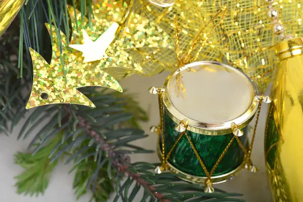 Weihnachtlicher Hintergrund mit Trommeln, grüner Silvesterbaum-Zweig, goldene Neujahrsdekoration — Stockfoto