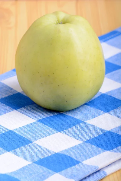 Färskt grönt äpple på blå materiella backgound — Stockfoto