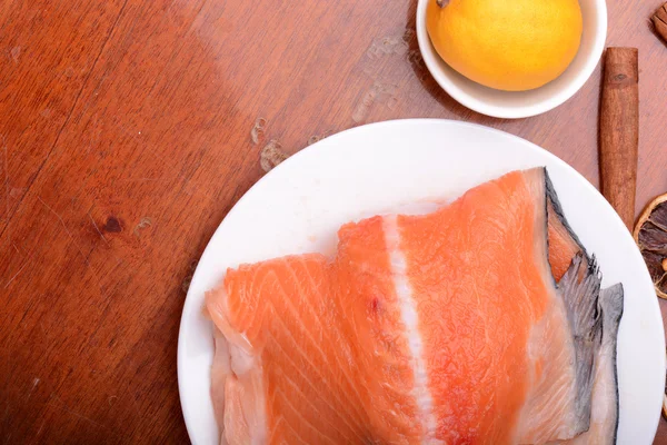 Raw salmon fish steaks with fresh herbs on white plate — Stock Photo, Image