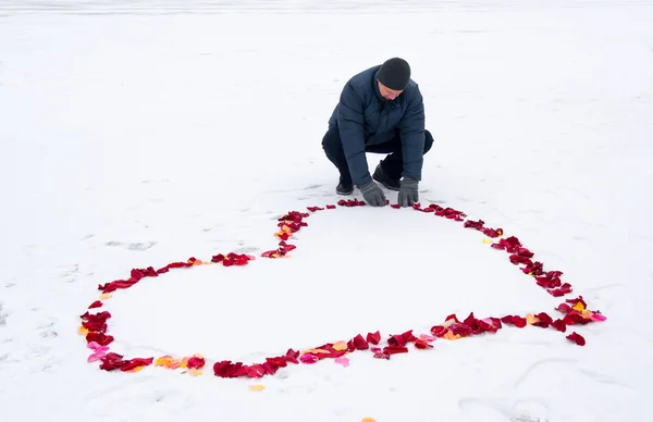 Bir adam ve bir kalp gül yaprakları — Stok fotoğraf