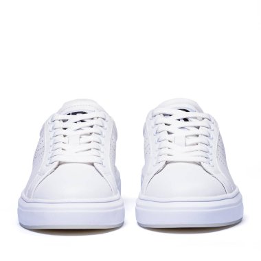 Tarafsız beyaz arka planda bağcıklı beyaz spor ayakkabılar..