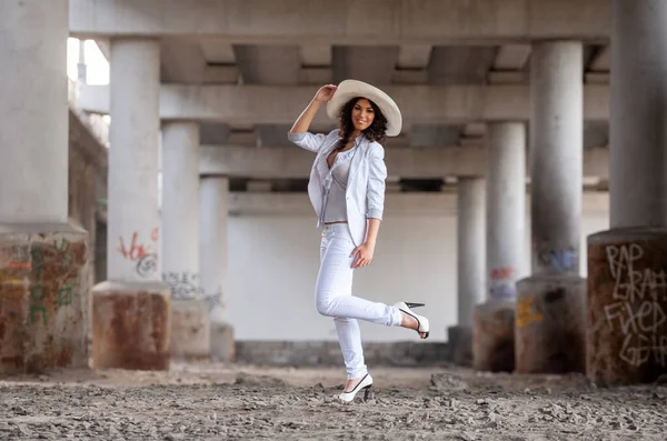Köprünün Altındaki Beton Sütunların Yanındaki Beyaz Elbiseli Genç Kadın — Stok fotoğraf