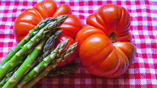 Pomidory Szparagi Czerwonym Obrusie — Zdjęcie stockowe