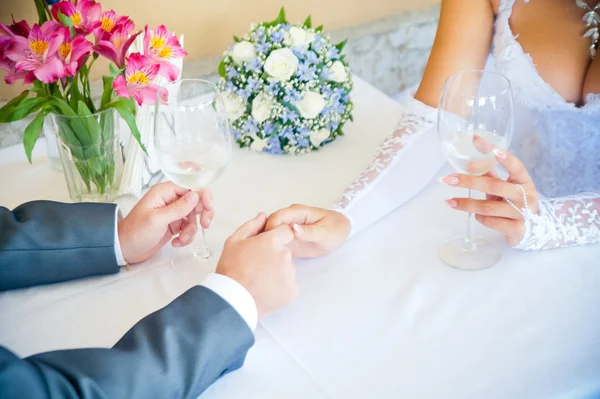 Lovers hold hands while sitting at a table — Stock Photo, Image