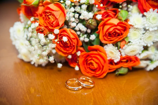 Svatební prsteny na bílém pozadí s kyticí modrých stuh — Stock fotografie