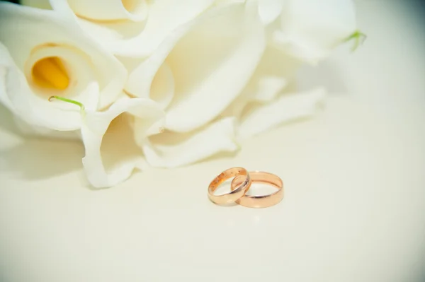 Wedding rings on the table on the background of the bride's bouq Royalty Free Stock Photos