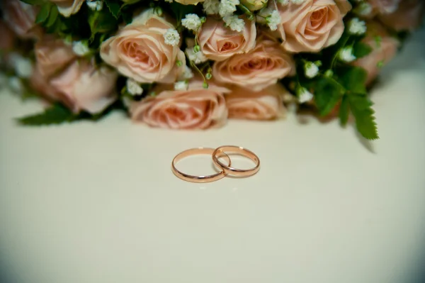 Anillos de boda sobre un fondo blanco con un ramo de ribbo azul Imágenes de stock libres de derechos