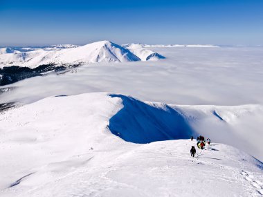 Grup dağcı tarafından karla kaplı dağ yükselir