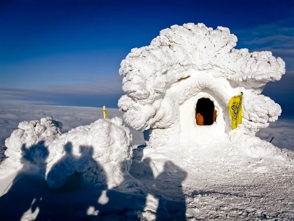 Casa innevata e turisti sulla cima di una montagna — Foto Stock