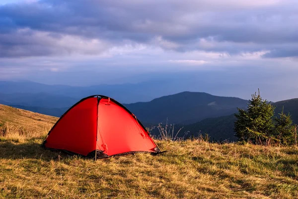 Red tent under clouds in mountains — Stock Photo, Image
