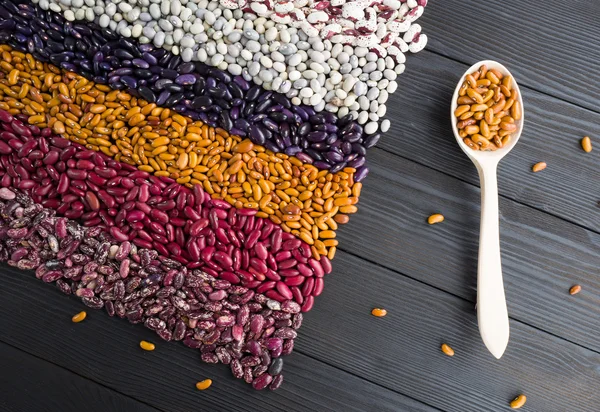 Spoon with haricots on wooden table — Stock Photo, Image