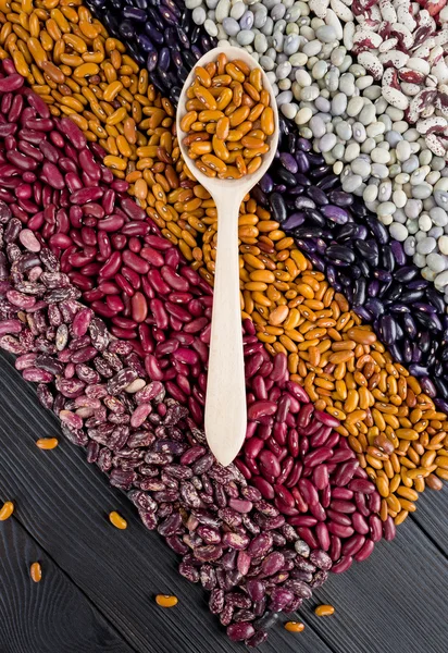 Spoon with haricots on wooden table — Stock Photo, Image