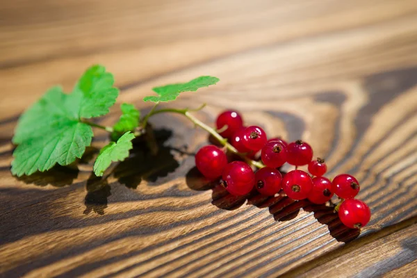 Red currant on a wooden table — Stock Photo, Image