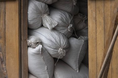 Büyük saman balyaları yağmurdan dolayı bir gölgeliğin altında yatıyor.