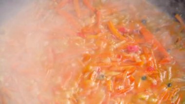 Demir bir kazanla açık havada pilav pişirmek.