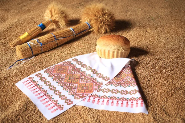 Tarwe bundel, brood en geborduurde handdoek — Stockfoto