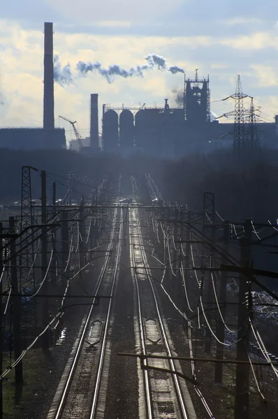 Spoorweg tegen staalfabriek — Stockfoto