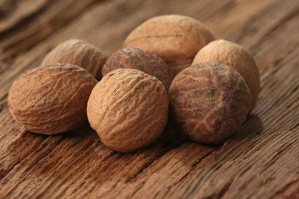 Nutmeg on an old table — Stock Photo, Image