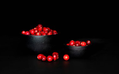 Siyah arka planlı, dökme demir kaselerde bir demet krantrik. Düşük tuşlu çekimler.