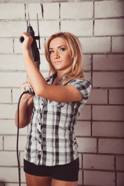 Elinde matkap tutan kadın.