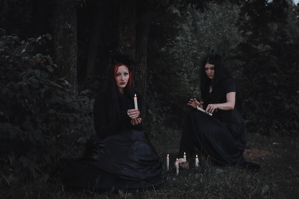 The witches conjure in a dark forest