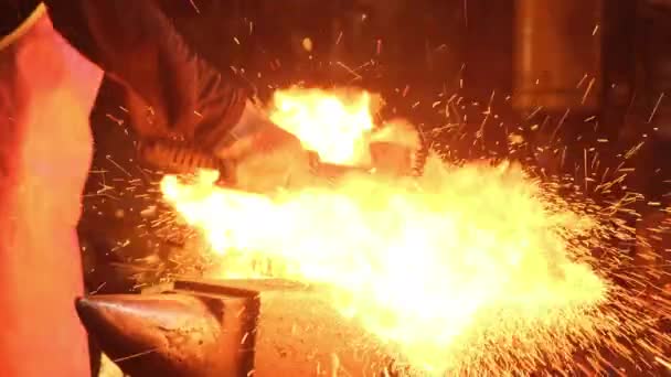 Medium shot of a man with a hammer hitting red-hot metal — Stock Video