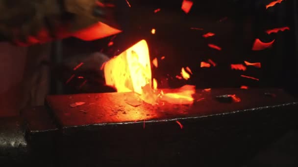 Primer plano, un hombre con un martillo golpea el metal caliente — Vídeo de stock