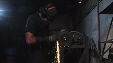 Metali kıvılcımlarla bileyen bir işçinin orta boy fotoğrafı.. 