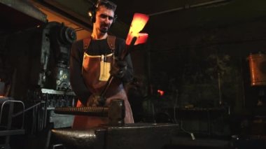 Parçayı kontrol eden bir demirciyle orta boy fotoğraf.
