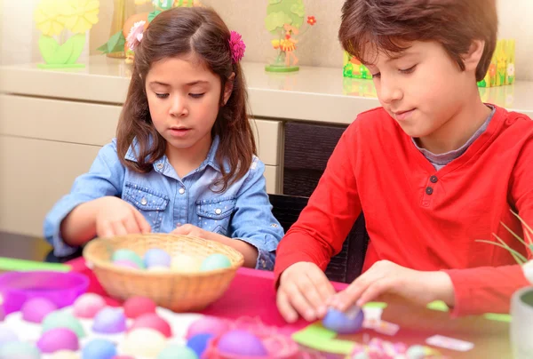 Brother and sister coloring Easter eggs — Stock Photo, Image