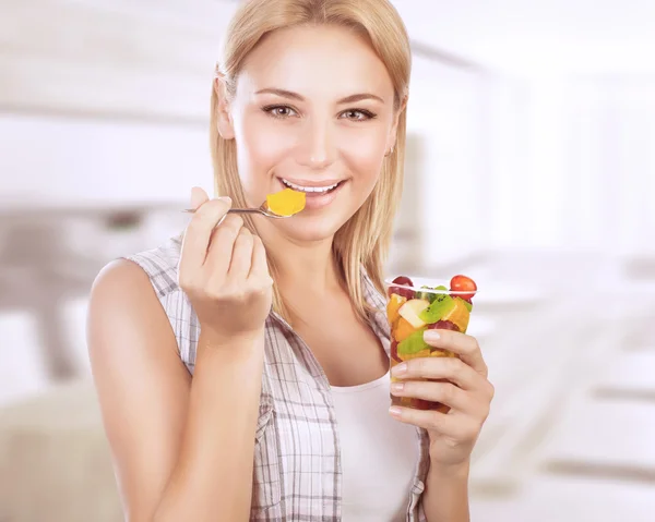 Mulher feliz comer salada de frutas — Fotografia de Stock