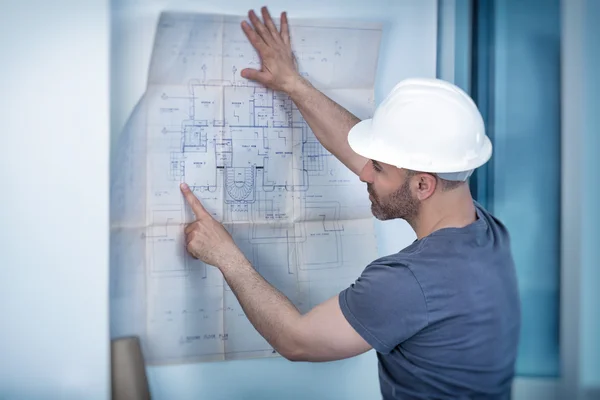 Architect builder studying layout plan of the rooms — Stock Photo, Image