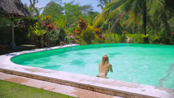 Uma mulher bonita numa piscina infinita. Vídeo em HD completo — Vídeo de Stock